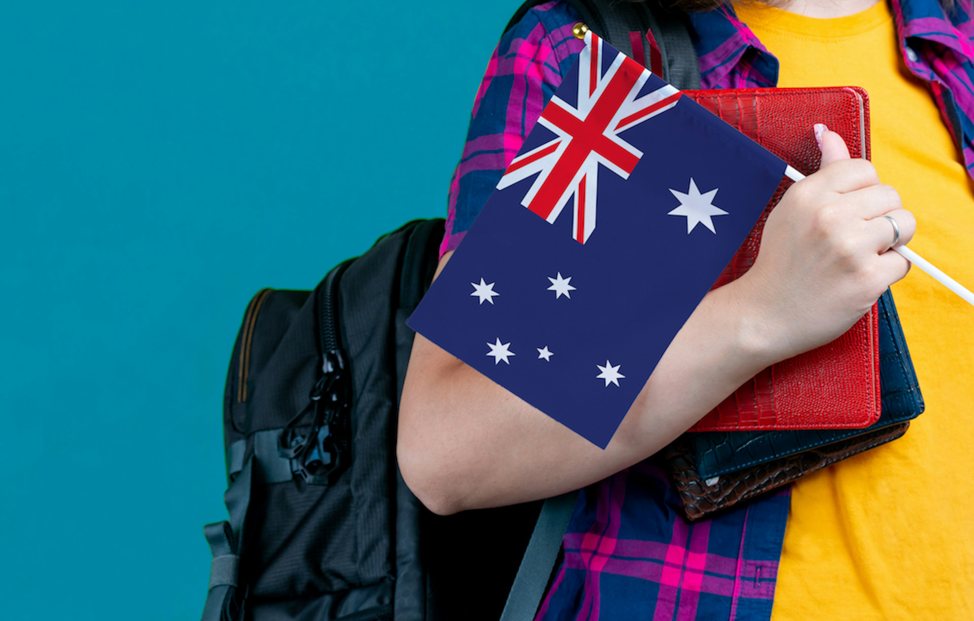 girl holding school books and an Australian flag